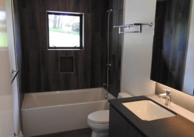 Modern bathroom interior with a bathtub, toilet, and a view through the window.