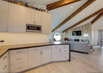 Modern kitchen interior with wooden beams and open-plan living space.