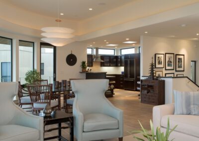 Modern open-plan living space featuring a dining area and kitchen with contemporary furniture and neutral color tones.