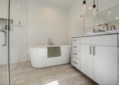 Modern bathroom interior with a freestanding bathtub and a vanity with cabinets.